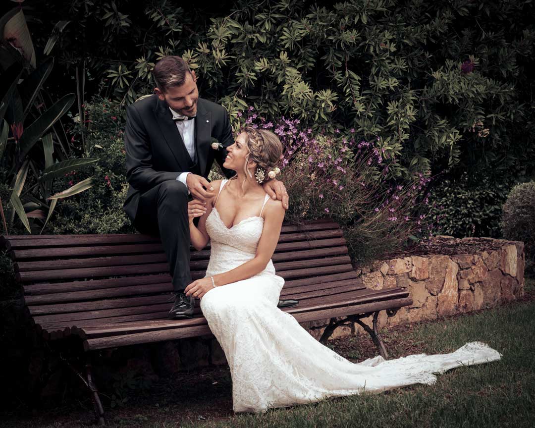 Pricing & Packages.-Premium Packages. Bride & Groom posing in the bench